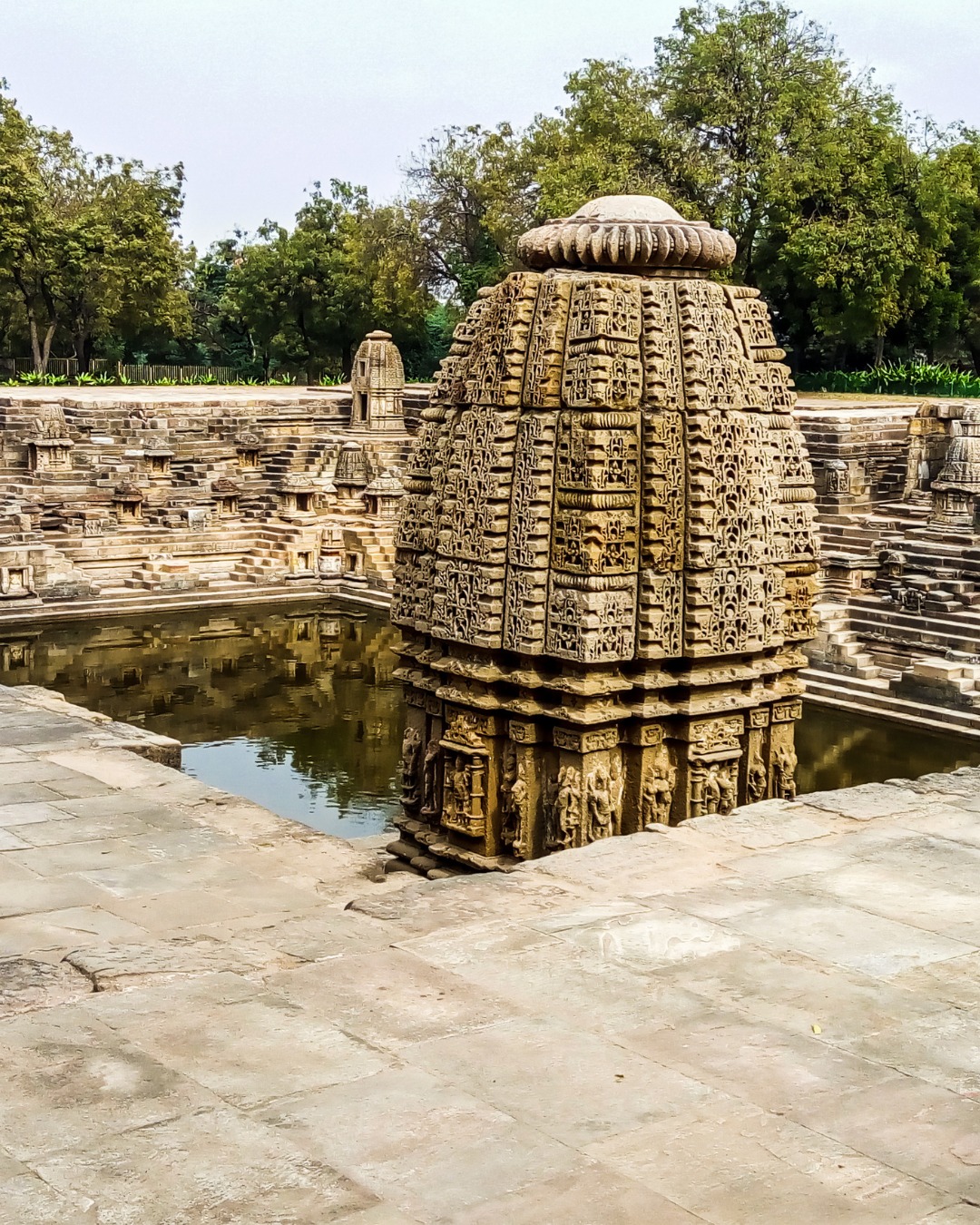 Modhera Sun Temple represents 11th-century Solanki dynasty sculpture at its finest – a temple dedicated to Surya that, while smaller and less known than Konark, offers something special: sculptural intimacy and preservation that allows close appreciation of artistic detail often impossible at grander sites.
Built in 1026 CE by King Bhimdev I, Modhera was designed so the sun's first rays would illuminate the sanctum during equinoxes. Though the main shrine lost its shikhara (spire) centuries ago, what remains showcases Solanki craftsmanship – every surface covered in carvings depicting gods, goddesses, celestial beings, animals, and intricate geometric patterns.
The assembly hall (sabha mandapa) features 52 pillars, each uniquely carved, supporting a ceiling covered in floral and geometric designs. Light filtering through creates constantly changing patterns on sculptured stone. The smaller scale means you can examine details closely – see how stone suggests fabric texture, observe individual expressions on faces, appreciate the technical precision in repetitive patterns that never quite repeat identically.
The stepped tank (kund) fronting the temple is equally impressive – a geometric marvel of platforms, steps, and shrines descending to water, all carved with miniature temples and sculptures creating three-dimensional mandala geometry.
Modhera's relative quiet – far fewer visitors than famous monuments – lets you experience these sculptures contemplatively.
#enrichingjourney
#TravelWithEJ
#ModheraSunTemple #Modhera #Gujarat #SunTemple #IndianSculpture #SculpturalMasterpieces #StepWell #GujaratHeritage #HiddenGems #India #IndiaTravel #TravelIndia #ExploreIndia #IncredibleIndia #GujaratTravel #WesternIndia #TempleArchitecture #IndianHeritage #TravelDeeper #CulturalHeritage #HeritageIndia #AncientArchitecture #StoneSculpture #IndianArt #OffbeatIndia #IndiaExperts